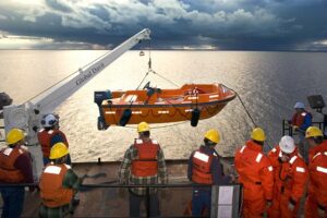 A Group Of People In Orange Life Jackets And Helmets